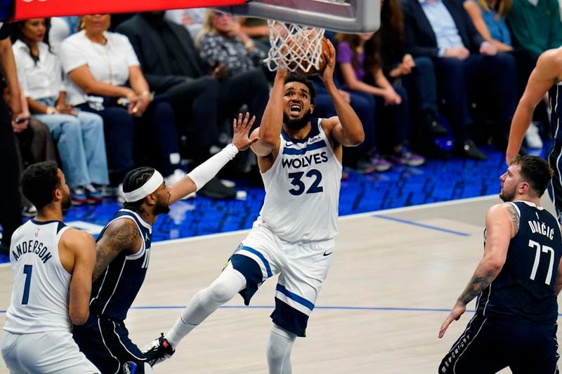 Minnesota Timberwolves center Karl-Anthony Towns (32) scores against the Dallas Mavericks during the second half in Game 3 of the NBA basketball Western Conference finals, Sunday, May 26, 2024, in Dallas. (AP Photo/Gareth Patterson)