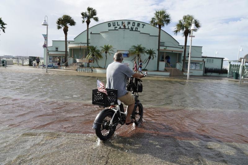 Louis Ward, 57, rides his bike along the the Gulfport waterfront as it takes on water as Hurricane Helene makes its way toward the Florida Panhandle, Thursday, Sept. 26, 2024 in Gulfport. (Martha Asencio-Rhine/Tampa Bay Times via AP)