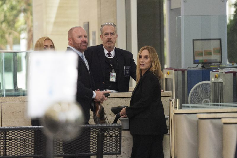 Mathew Bowyer, second from left, a Southern California bookbinder, and his attorney Diane Bass, right, enter federal court in Santa Ana, Calif., Friday, Aug. 9, 2024. (AP Photo/Damian Dovarganes)