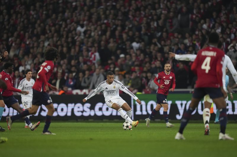 Real Madrid's Kylian Mbappe, center dribbles the ball during the Champions League opening phase soccer match between Lille and Real Madrid at the Stade Pierre Mauroy in Villeneuve-d'Ascq, outside Lille, France, Wednesday, Oct. 2, 2024. (AP Photo/Thibault Camus)