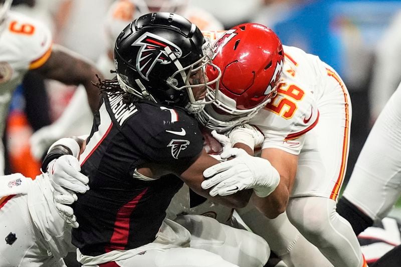 Kansas City Chiefs defensive end George Karlaftis (56) hits Atlanta Falcons running back Bijan Robinson (7) during the first half of an NFL football game, Sunday, Sept. 22, 2024, in Atlanta. (AP Photo/Brynn Anderson)