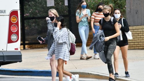 Students wear masks as they make their way through the University of Georgia campus in Athens in September. Athens-Clarke County is likely to revive a partial mask mandate to stem the spread of the coronavirus before students return to classes at UGA on Aug. 18. (Hyosub Shin / Hyosub.Shin@ajc.com)