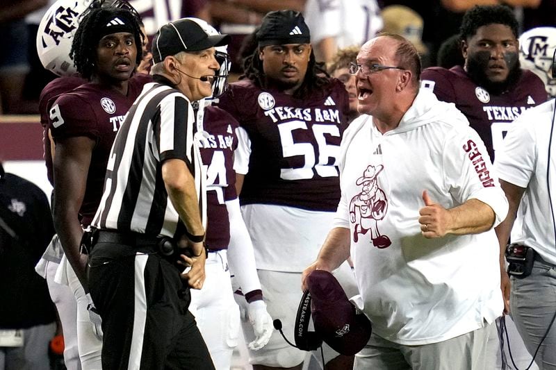 Texas A&M head coach Mike Elko, front right, argues a non call with an official, front left, during the second half of an NCAA college football game against Notre Dame, Saturday, Aug. 31, 2024, in College Station, Texas. (AP Photo/Sam Craft)