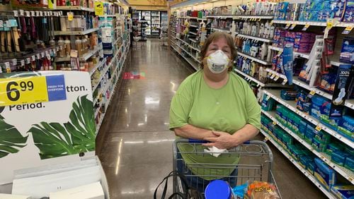 Julie Kirby shopping at the Kroger on Dallas Highway in west Cobb early Wendesday morning. Her pharmacist daughter urged her to don the mask. Jim Galloway, jgalloway@ajc.com