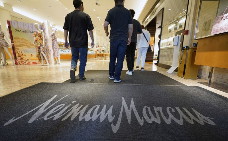 FILE - Shoppers walk into the Neiman Marcus retail department store at NorthPark shopping center in Dallas, March 30, 2023. The parent company of Saks Fifth Avenue has signed a deal to buy upscale rival Neiman Marcus for $2.65 billion. The buyout was announced Thursday, July 4, 2024, after months of rumors that the department store chains had been negotiating a deal. (AP Photo/LM Otero, File)
