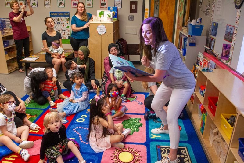 Teacher Emily Broich reads aloud to her kids and their mothers at B.B. Harris Elementary school in Duluth Friday May 13, 2022. (Steve Schaefer / steve.schaefer@ajc.com)