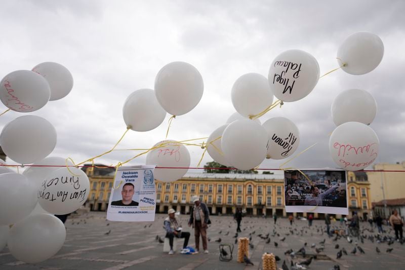 Photos and balloons representing people detained by Venezuelan security forces after Venezuela's presidential election hang at Bolivar square in Bogota, Colombia, Wednesday, Aug. 28, 2024, during a protest against the reelection of President Nicolas Maduro one month after the disputed vote which the opposition says it won by a landslide. (AP Photo/Fernando Vergara)