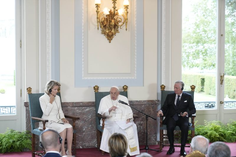 Pope Francis flanked by King Philippe and Queen Mathilde delivers his message during a meeting with the authorities and the civil society in the Grande Galerie of the Castle of Laeken, Brussels, Friday, Sept. 27, 2024. (AP Photo/Andrew Medichini)