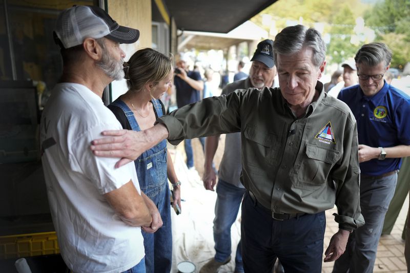 North Carolina governor Roy Cooper greets people on Thursday, Oct. 3, 2024, in Boone, N.C. in the aftermath of hurricane Helene. In the final weeks of the presidential election, people in North Carolina and Georgia, influential swing states, are dealing with more immediate concerns: recovering from Hurricane Helene. (AP Photo/Chris Carlson)