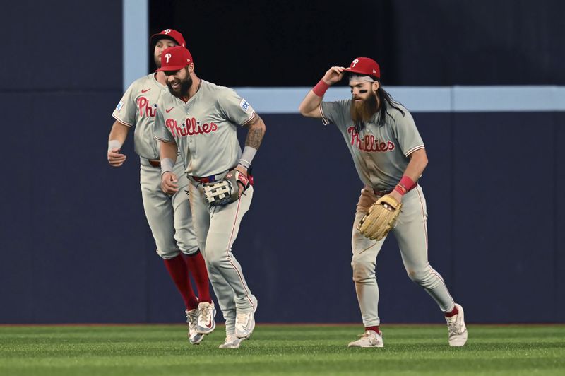 From left, Philadelphia Phillies' Kody Clemens, Weston Wilson and Brandon Marsh celebrate their team's victory over the Toronto Blue Jays in a baseball game in Toronto on Tuesday, Sept. 3, 2024. (Jon Blacker/The Canadian Press via AP)