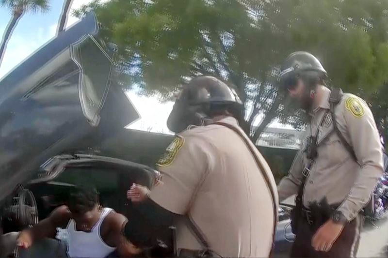 Police body camera video shows that an officer dragging Miami Dolphins wide receiver Tyreek Hill out of his sports car by his arm and head and then forcing him face first onto the ground after Hill put up the window of his sports car. (Miami-Dade Police Department)