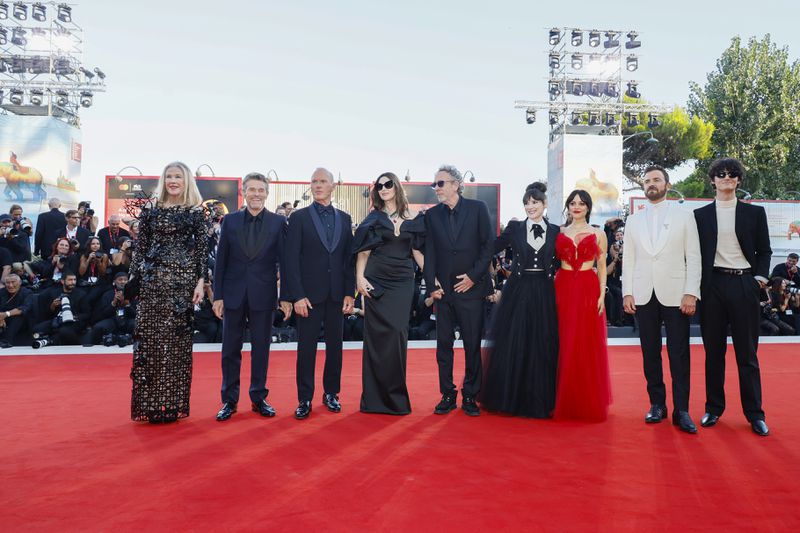 Catherine O'Hara, from left, Willem Dafoe, Michael Keaton, Monica Bellucci, director Tim Burton, Winona Ryder, Jenna Ortega, Justin Theroux and Arthur Conti pose for photographers upon arrival for the premiere of the film 'Beetlejuice Beetlejuice' and the opening ceremony of the 81st edition of the Venice Film Festival in Venice, Italy, on Wednesday, Aug. 28, 2024. (Photo by Joel C Ryan/Invision/AP)