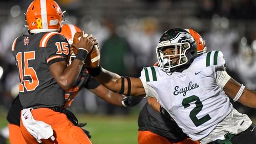 Collins Hill’s Deuce Geralds (2) rushes North Cobb quarterback Nick Grimstead (15) during the first half of play Friday, during a 2023 game at North Cobb High School. (Daniel Varnado/For the AJC)