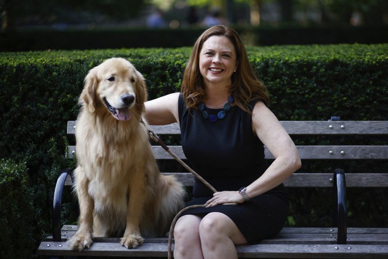 Tania Tetlow president of Fordham University poses next to her dog Archie during Move In Day at the Bronx campus, Sunday Aug. 25, 2024, in New York. (AP Photo/Kena Betancur)