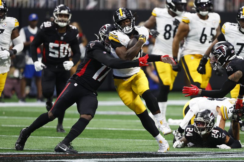 Pittsburgh Steelers running back Najee Harris (22) is stopped by Atlanta Falcons linebacker Arnold Ebiketie (17) during the second half of an NFL football game Sunday, Sept. 8, 2024, in Atlanta. (AP Photo/Butch Dill)