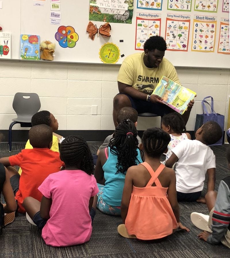 Brandon Adams reads to children in Horizons Atlanta, a summer-learning program for at-risk children with one location at Georgia Tech.  Adams' mother Lisa Greer said that he had a particular fondness for children “just because he was such a big guy and the kids would kind of, like, run and jump on him.” 