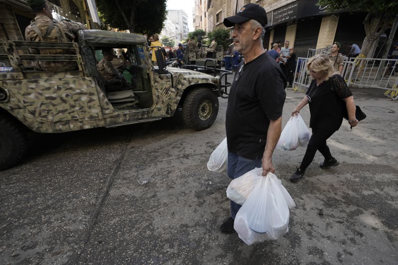 Lebanese soldiers drive near the site of Friday's Israeli strike in Beirut's southern suburb, Sunday, Sept. 22, 2024. (AP Photo/Bilal Hussein)