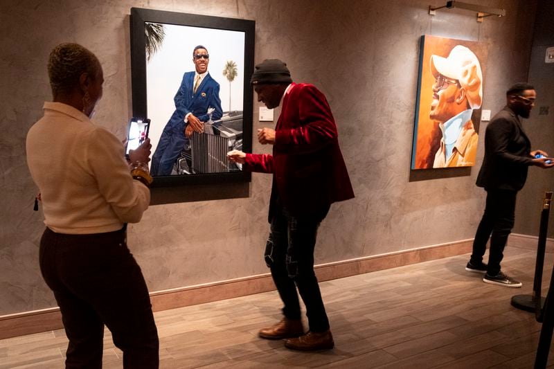 LaTonya Holmes records Relentless Aaron dance during Art Melanated’s Stevie Wonder exhibit opening at Thompson Atlanta in Buckhead on Friday, Feb. 2, 2024.   (Ben Gray / Ben@BenGray.com)
