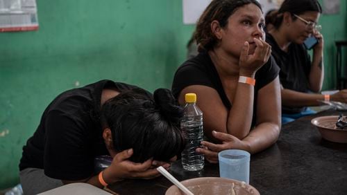 Yeneska Garcia, a Venezuelan migrant, cries into her hands as she eats at the Peace Oasis of the Holy Spirit Amparito shelter in Villahermosa, Mexico, Friday, June 7, 2024. Since the 23-year-old fled Venezuela in January, she trekked days through the jungles of The Darien Gap, narrowly survived being kidnapped by Mexican cartels and waited months for an asylum appointment with the U.S. that never came through. (AP Photo/Felix Marquez)