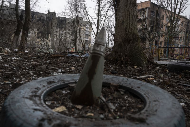 FILE - A part of a rocket sticks from a ground in front of a residential building which was heavily bombed by Russian forces in the frontline city of Vuhledar, Ukraine, Feb. 25, 2023. (AP Photo/Evgeniy Maloletka)