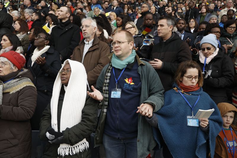 Faithful listen as Pope Francis presides the holy mass , at the King Baudouin stadium in Brussels, Belgium, Sunday, Sept. 29, 2024. (AP Photo/Omar Havana)