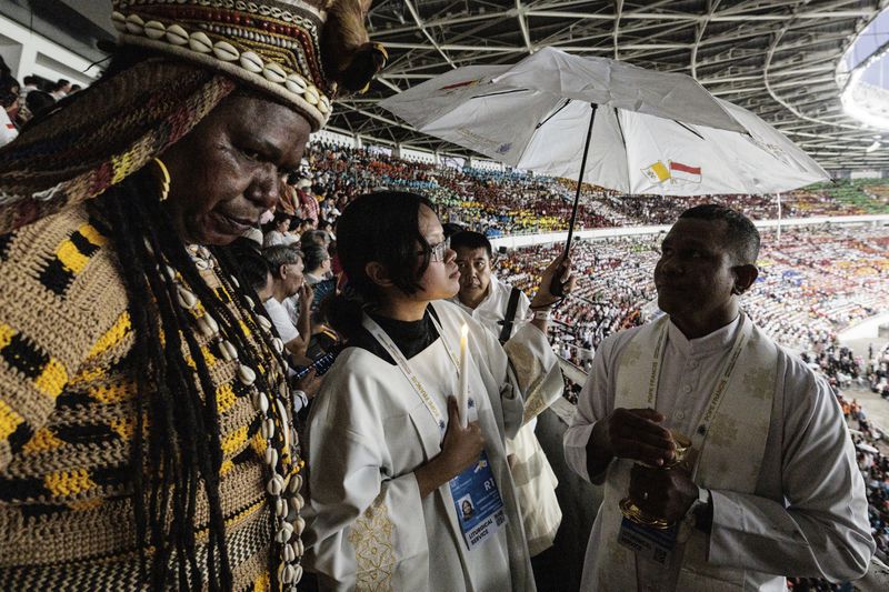 A priest gives Holy Communion to the faithful during a holy mass led by Pope Francis at the Gelora Bung Karno Stadium, in Jakarta, Thursday, Sept. 5, 2024. (Yasuyoshi Chiba/Pool Photo via AP)