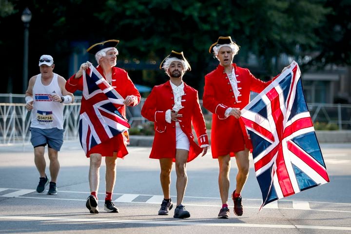 People head to the starting line dressed in British costumes before the start of the 55th Atlanta Journal-Constitution Peachtree Road Race in Atlanta on Thursday, July 4, 2024.  (Arvin.Temkar / ajc.com)