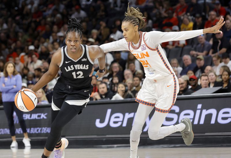 Las Vegas Aces guard Chelsea Gray (12) drives around Connecticut Sun forward DeWanna Bonner (24) during the first half of an WNBA basketball game Sunday, Sept. 15, 2024, in Las Vegas. (Steve Marcus/Las Vegas Sun via AP)