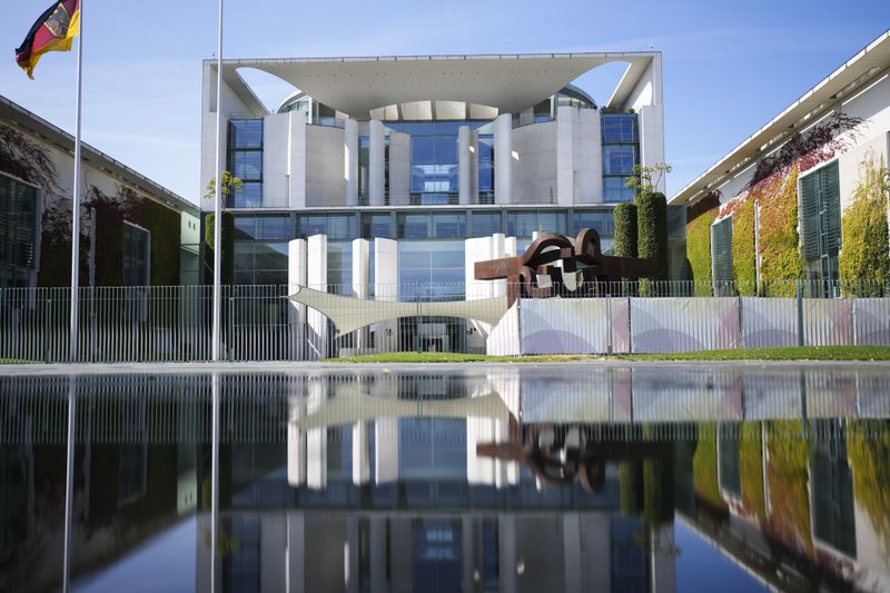 The Chancellery with the office of German Chancellor Olaf Scholz is reflected in a puddle in Berlin, Germany, Monday, Sept. 2, 2024. (AP Photo/Markus Schreiber)