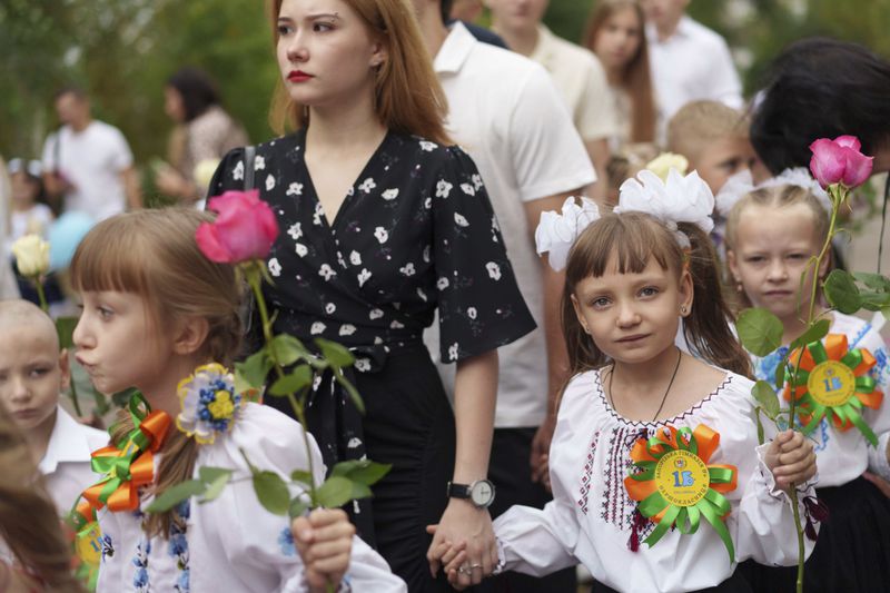 First-grades walk to the traditional ceremony for the first day of school in Zaporizhzhia, Ukraine, Sunday Sept. 1, 2024. Zaporizhzhia schoolchildren celebrated the traditional first day of school near the frontline. With the front just 40 kilometers away, the war is never far from the minds of teachers and families. (AP Photo/Evgeniy Maloletka)