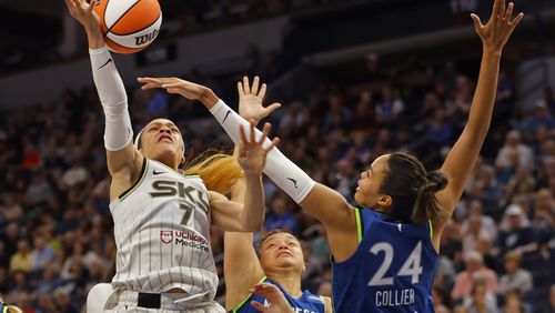 Chicago Sky guard Chennedy Carter (7) goes to the basket as Minnesota Lynx guard Kayla McBride, center, and forward Napheesa Collier (24) guard against her in the third quarter of a WNBA basketball game Friday, Sept. 13, 2024, in Minneapolis. (AP Photo/Bruce Kluckhohn)