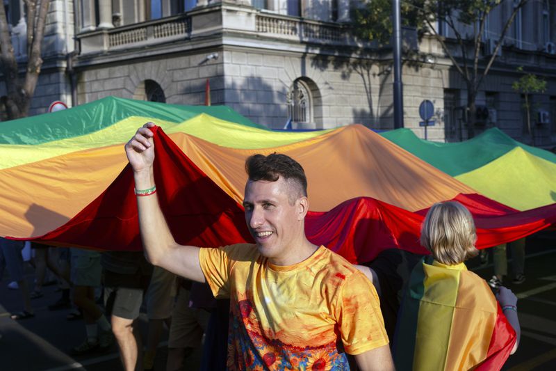 People carry a large rainbow flag while attending a pride march in Belgrade, Serbia, Saturday, Sept. 7, 2024 as they demand that the government improve rights for the LGBTQ+ community who often face harassment and discrimination in the highly conservative Balkan country. (AP Photo/Marko Drobnjakovic)