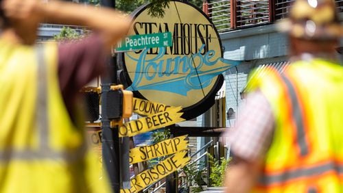 Workers that have been working on the city’s water main breaks are seen in front of Steamhouse Lounge in Atlanta on Thursday, June 6, 2024. The restaurant just re-opened after being closed for five days following several water main breaks. (Arvin Temkar / AJC)