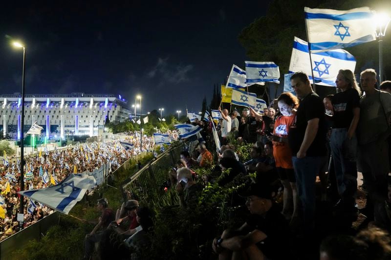 Family members and supporters of the hostages held captive by Hamas in Gaza complete the final leg of a four-day march from Tel Aviv to Jerusalem to demand the immediate release of all hostages, outside the Prime Minister's office in Jerusalem on Saturday, July 13, 2024. (AP Photo/Mahmoud Illean)