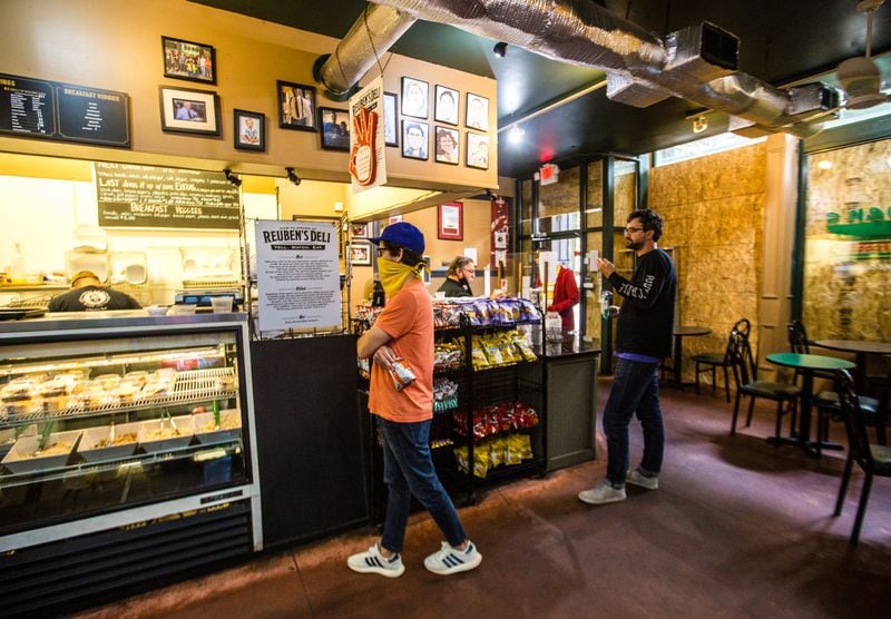 Ruben’s Deli on Broad Street in the Fairlie-Poplar District downtown is open for business despite broken windows. Businesses throughout downtown are boarded up Wednesday, June 17, 2020. (Jenni Girtman for The Atlanta Journal-Constitution)