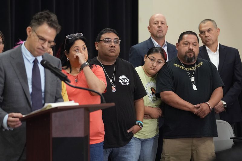 Families of the victims in the Uvalde elementary school shooting listen to attorney Josh Koskoff during a news conference, Wednesday, May 22, 2024, in Uvalde, Texas. The families of 19 of the victims announced a lawsuit against nearly 100 state police officers who were part of the botched law enforcement response. The families say they also agreed a $2 million settlement with the city, under which city leaders promised higher standards and better training for local police. (AP Photo/Eric Gay)