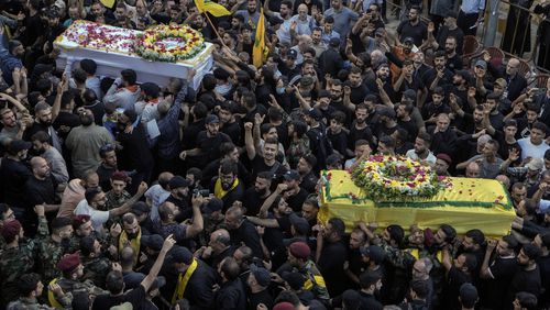 Mourners carry the coffins of victims who were killed Tuesday after their handheld pagers exploded, during their funeral procession in the southern suburb of Beirut, Lebanon, Wednesday, Sept. 18, 2024. (AP Photo/Bilal Hussein)