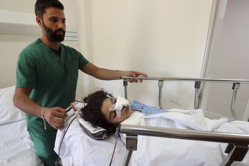 Fatima Abdel Rahman Zorout, 7, who was wounded in an Israeli airstrike, is wheeled on a gurney at the Alaaeddine Hospital in Sarafand, south Lebanon, Thursday, Sept. 26, 2024. (AP Photo/Mohammed Zaatari)