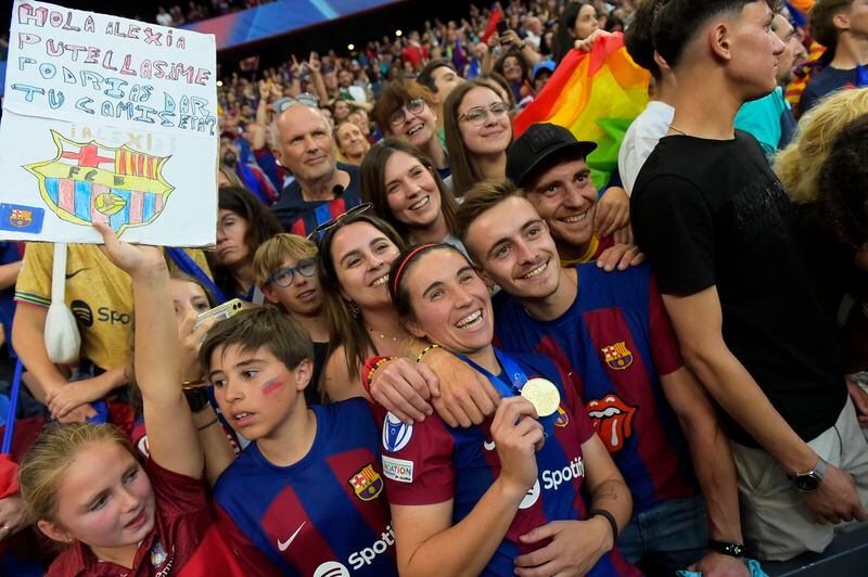 Barcelona's Mariona Caldentey holds her medal posing with fans after winning the women's Champions League final soccer match between FC Barcelona and Olympique Lyonnais at the San Mames stadium in Bilbao, Spain, Saturday, May 25, 2024. Barcelona won 2-0. (AP Photo/Alvaro Barrientos)