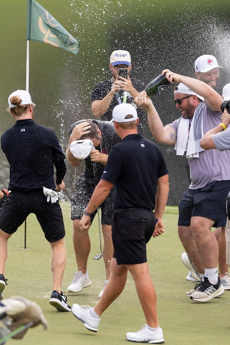 Legion XIII's Kieran Vincent, captain Jon Rahm and Caleb Surratt celebrate with first place individual champion Tyrrell Hatton, center, on the 18th green during the final round of LIV Golf Nashville at The Grove, Sunday, June 23, 2024, in College Grove, Tenn. (Chris Trotman/LIV Golf via AP)
