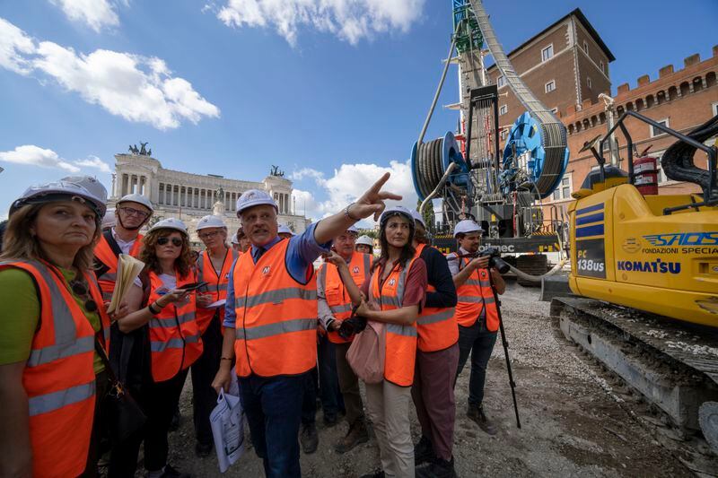 Chief engineer Andrea Sciotti, center, technical director for Rome's new 25.5-kilometer Metro C subway talks to international journalists at the construction site of line C main hub in central Rome, Thursday, May 23, 2024. During a tour Thursday of the construction site at Piazza Venezia, Sciotti said works on the nearly 3 billion euro project, considered one of the most complicated in the world, were running at pace to be completed by 2034. In the background the Unknown Soldier monument. (AP Photo/Domenico Stinellis)