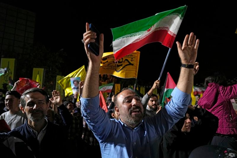 Demonstrators cheer as they wave Iranian and Hezbollah flags in an anti-Israeli gathering celebrating Iran's missile strike against Israel, at Felestin (Palestine) Sq. in Tehran, Iran, Tuesday, Oct. 1, 2024. (AP Photo/Vahid Salemi)