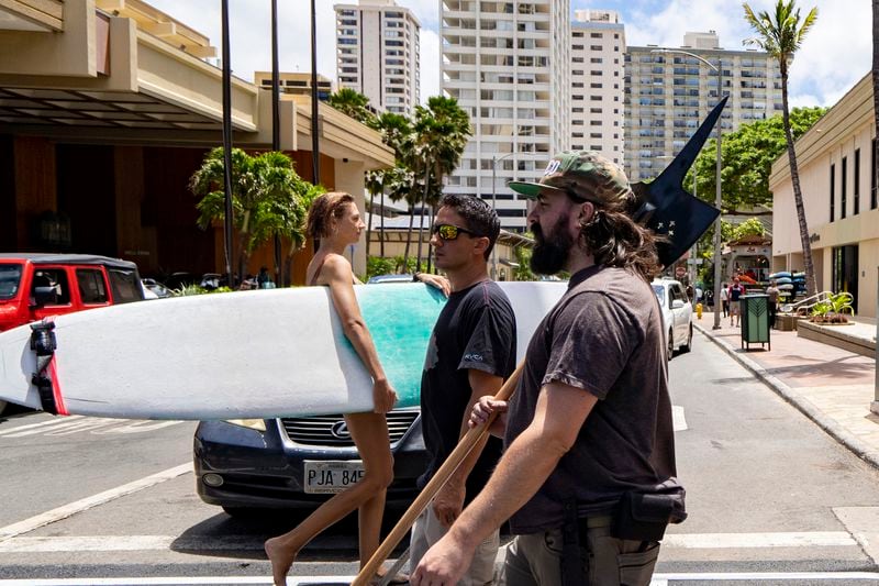 Andrew Roberts, director of the Hawaii Firearms Coalition, holds a halberd while walking down Kalakaua Avenue in Waikiki on Saturday, June 22, 2024, in Honolulu, Hawaii. (AP Photo/Mengshin Lin)