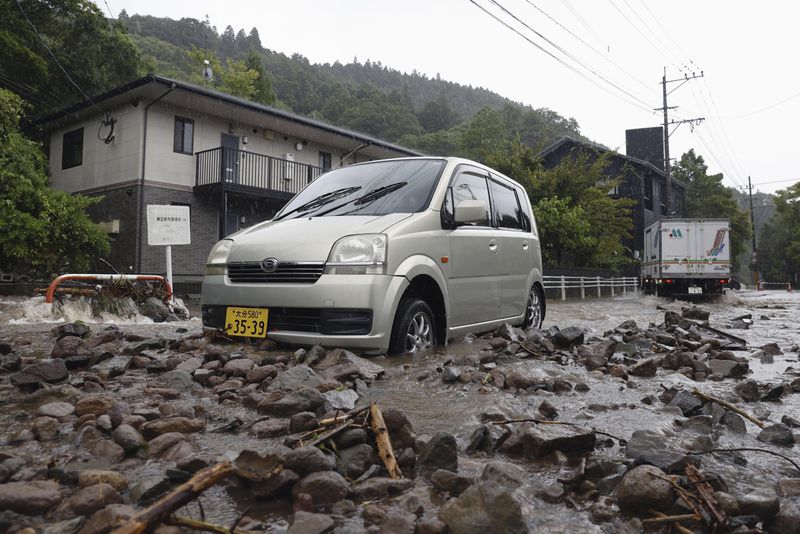 A road is covered by mud and stones as a typhoon hits the city in Yufu, Oita prefecture western Japan, Thursday, Aug. 29, 2024. (Kyodo News via AP)