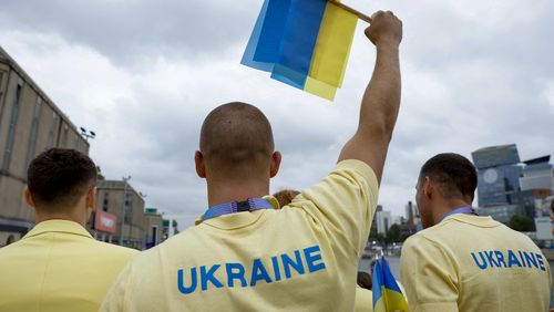 Ukraine's athletes stand on a boat ahead of the opening ceremony for the 2024 Summer Olympics on the Seine River in Paris, France, Friday, July 26, 2024. (Clodagh Kilcoyne/Pool Photo via AP)