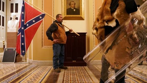 A man carries a Confederate flag as a mob protests the presidential election results, inside the Capitol in Washington on Wednesday, Jan. 6, 2021. The Trump era has been marked by open expressions of racial bigotry. (Erin Schaff/The New York Times)