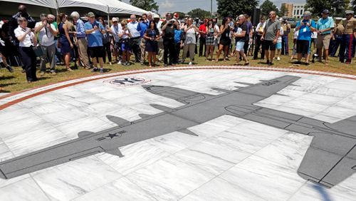 FILE - Family members and others look at a monument honoring the 15 Marines and one Navy corpsman who died in a July 10, 2017, U.S. military plane crash near Itta Bena, Miss., during an unveiling ceremony for the monument on July 14, 2018. Federal prosecutors said Wednesday, July 3, 2024, that a former engineer at a U.S. military air logistics center has been charged with making false statements and obstructing justice during the criminal investigation into the crash of the plane that had the call sign "Yanky 72." (AP Photo/Rogelio V. Solis, File)
