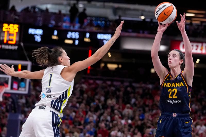 Indiana Fever guard Caitlin Clark (22) shoots over Dallas Wings guard Sevgi Uzun (1) in the second half of a WNBA basketball game in Indianapolis, Sunday, Sept. 15, 2024. (AP Photo/Michael Conroy)