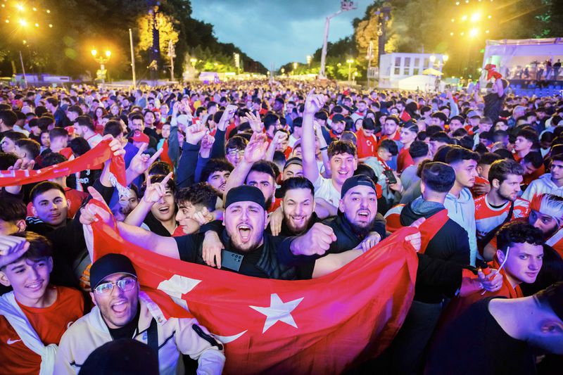 Turkey's fans cheer in the fan zone at the Brandenburg Gate in Berlin, Germany, July 2, 2024 during the screening of a round of sixteen match between Austria and Turkey at the Euro 2024 soccer tournament in Leipzig, Germany. (Christoph Soeder/dpa via AP)
