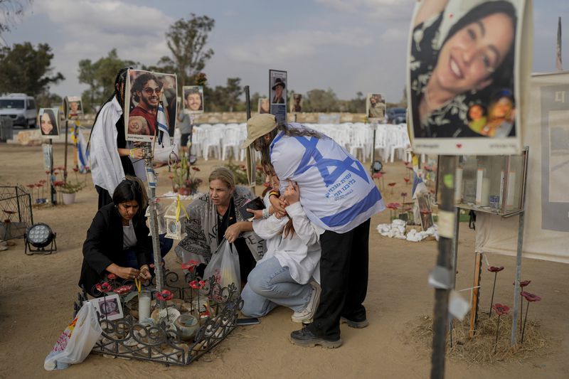 Peopls visit the site of the Nova music festival, where hundreds of revelers were killed and abducted by Hamas, on the eve of the one-year anniversary of the attack, near Kibbutz Reim, southern Israel, Sunday, Oct. 6, 2024. (AP Photo/Ohad Zwigenberg)